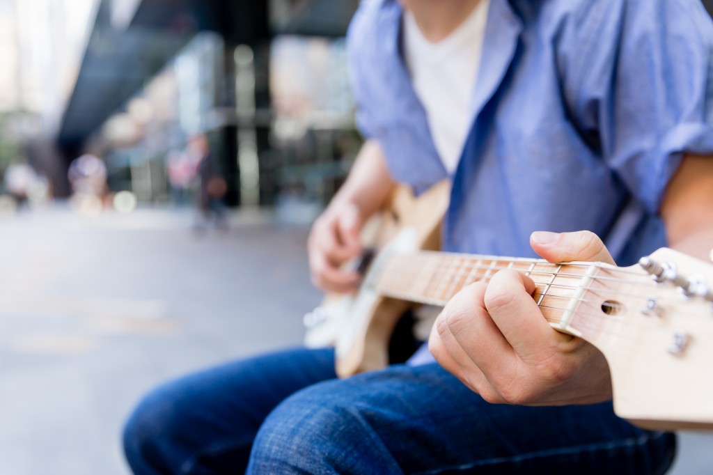 Young musician with guitar in city