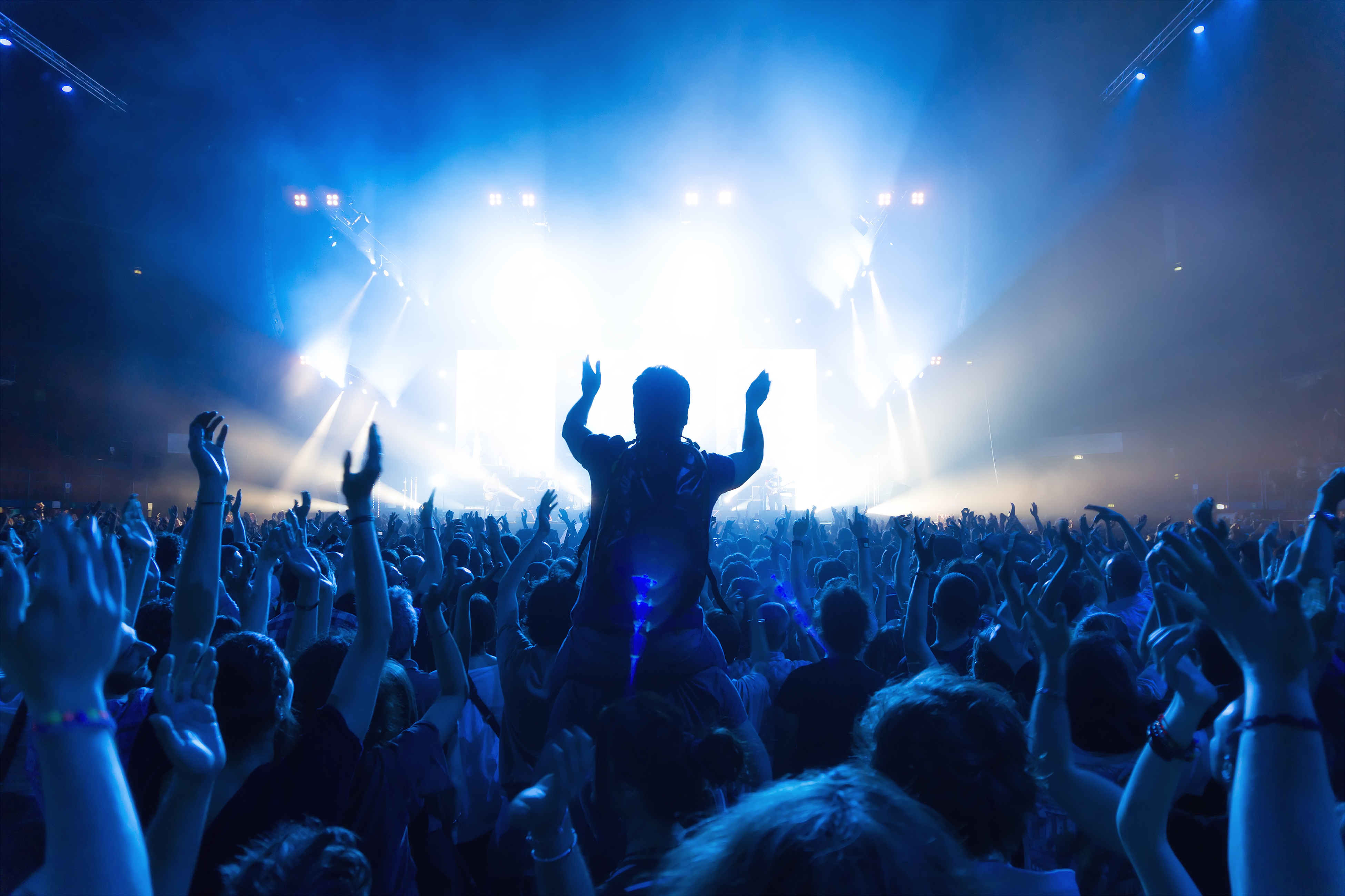 crowd of people at concert in front of the stage with lights - Music